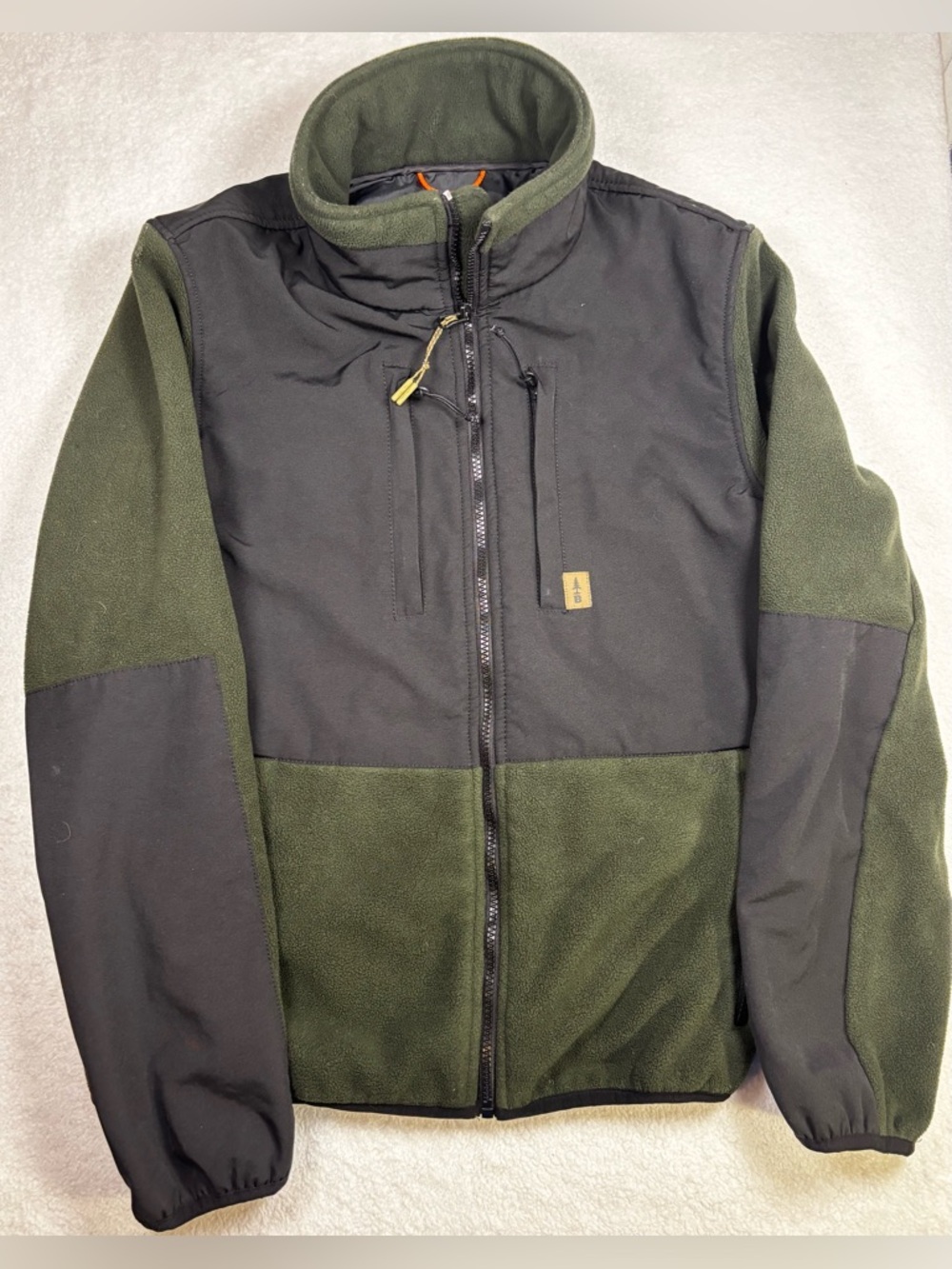 Bass Outdoor small green fleece jacket with black panels,and zip chest pocket.